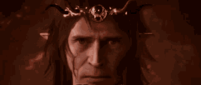 a man with horns and a crown on his head looks at the camera