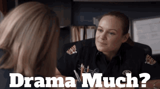 a woman in a firefighter uniform talks to another woman with the words drama much below her