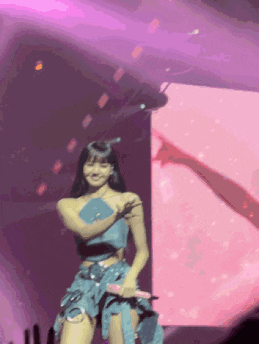 a woman in a blue dress is dancing on a stage