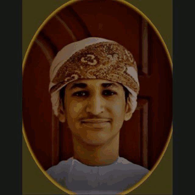 a young man wearing a turban and a white shirt is smiling