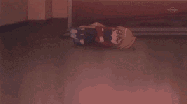 a girl is laying on the floor hugging herself with a tv behind her