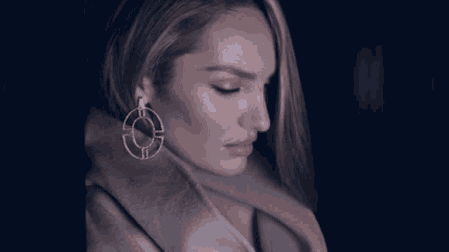 a close up of a woman 's face wearing a pair of hoop earrings