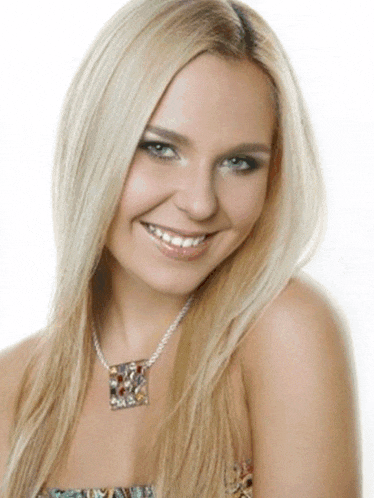 a blonde woman wearing a necklace with a square pendant