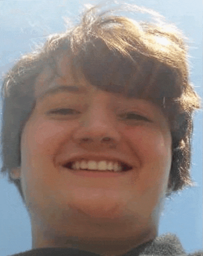 a close up of a young man 's face smiling