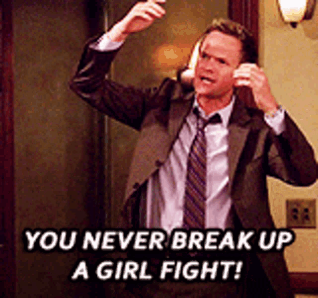 a man in a suit and tie is talking on a cell phone and says you never break up a girl fight
