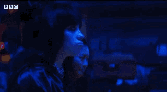 a blurry picture of a person in a dark room with bbc written on the bottom right