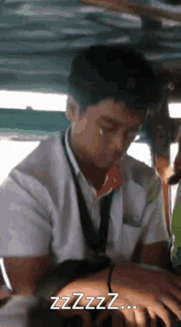 a man in a white shirt is yawning while sitting in a chair