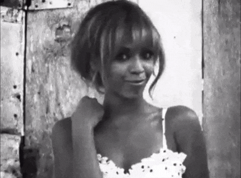 a black and white photo of a woman in a polka dot dress .