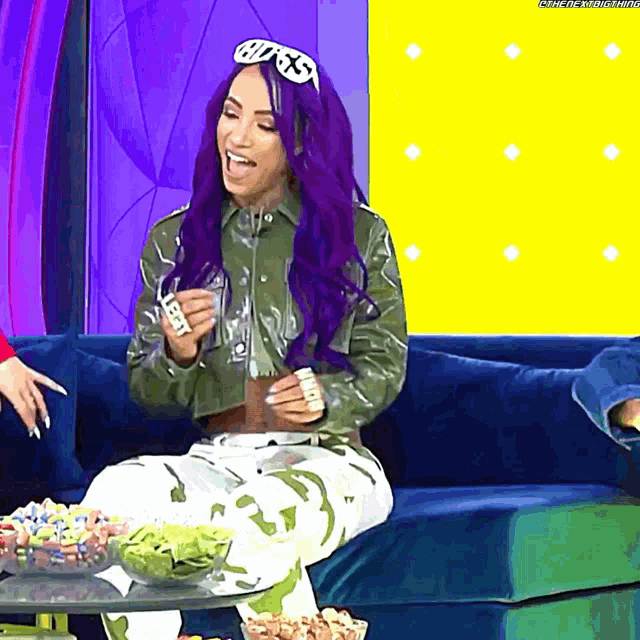 a woman with purple hair is sitting on a couch wearing sunglasses that say boss
