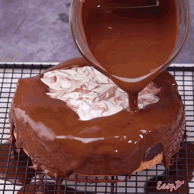 chocolate is being poured over a cake with easy do written on the bottom right