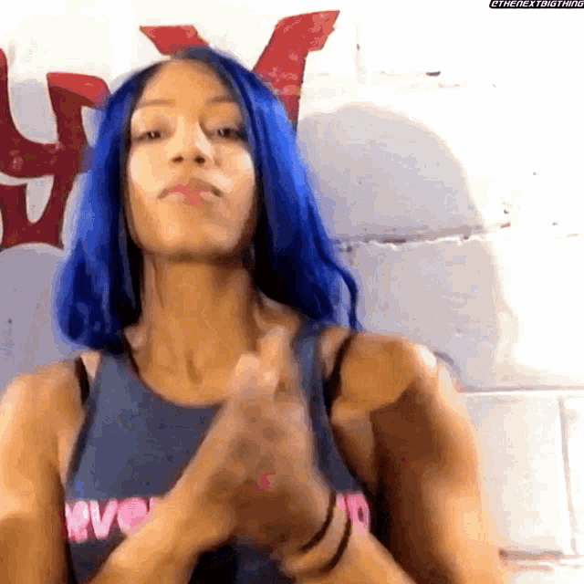 a woman with blue hair is wearing a tank top that says love