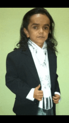 a young boy with long hair is wearing a suit