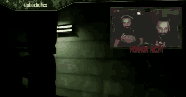 two men are sitting in front of a screen which says horror night