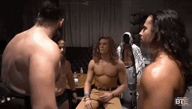 a group of men without shirts are standing next to each other in a room with the word bte on the bottom