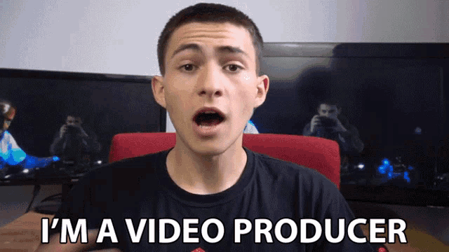 a young man says i 'm a video producer in front of two monitors