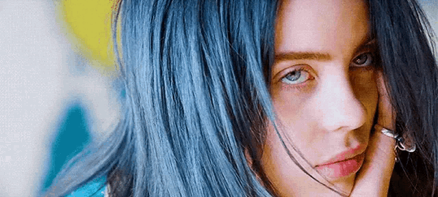 a close up of a person 's face with blue hair .