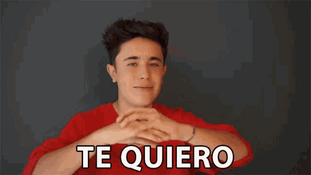 a young man in a red shirt making a heart shape with his hands with the words te quiero below him