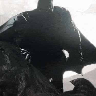 a close up of a person in a batman costume standing on a rock .
