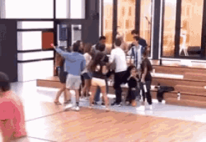 a group of people are standing on a wooden floor in a room