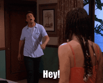 a man and a woman are standing in a room and the woman is saying hey