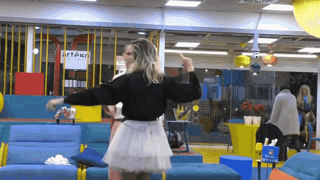 a woman dancing in a room with a sign that says artex
