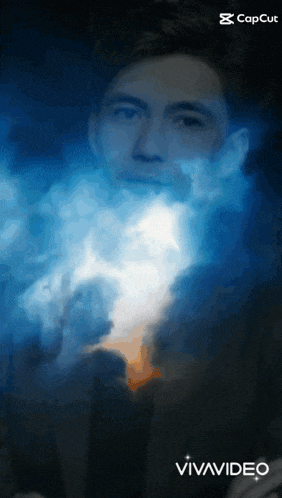 a man in a suit is surrounded by blue smoke and the words vivavideo on the bottom right