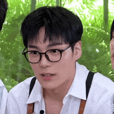 a close up of a man wearing glasses and suspenders .