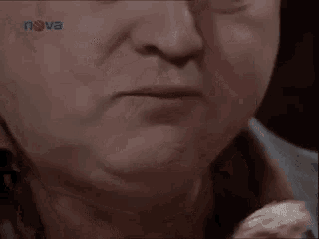 a close up of an elderly woman 's face with nova written on the bottom of the screen .