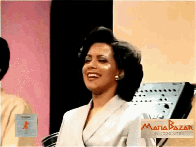 a woman is smiling in front of a sign that says mafia bazar in concerto