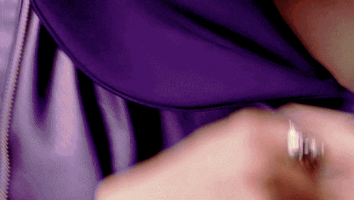 a close up of a person wearing a purple shirt and a silver ring