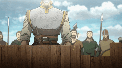 a group of men are standing behind a wooden fence and one of them has a belt with a z on it