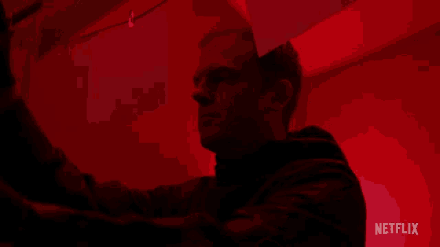 a man is standing in a dark room with a netflix logo in the corner