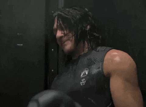 a close up of a man 's muscles in a tank top in a locker room .