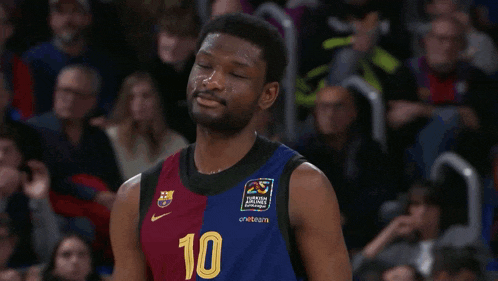 a man wearing a barcelona airlines jersey applauds