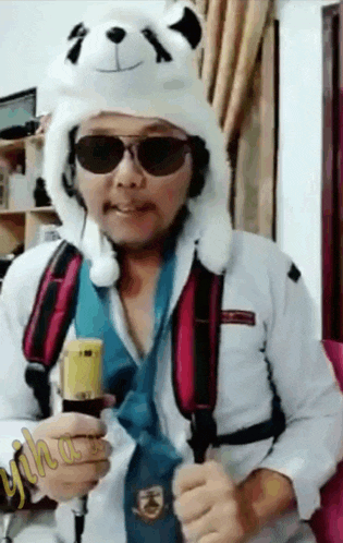a man wearing a teddy bear hat and sunglasses holds a banana