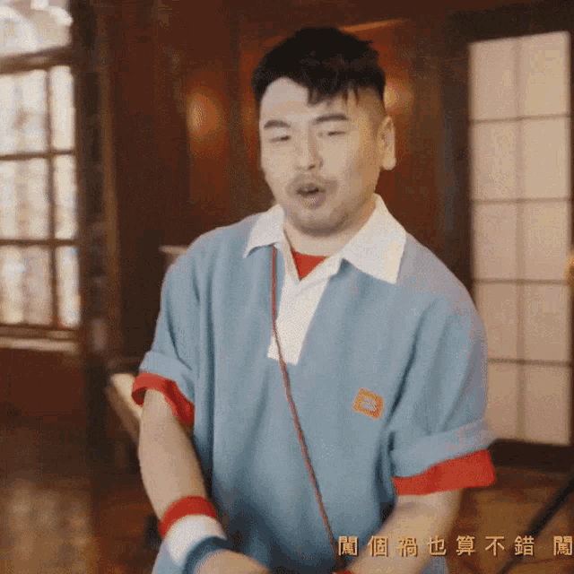 a man in a blue shirt has chinese writing on the bottom of his shirt