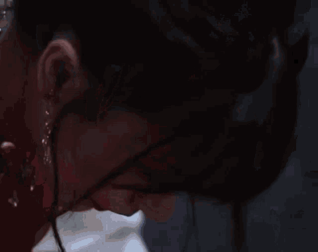 a close up of a woman wearing earrings and red lipstick .