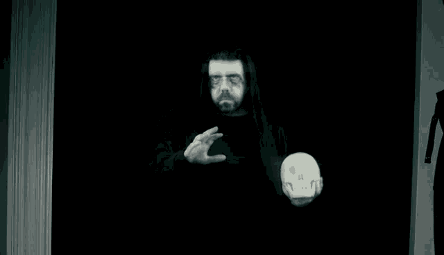 a man with dreadlocks holds a skull in his hands