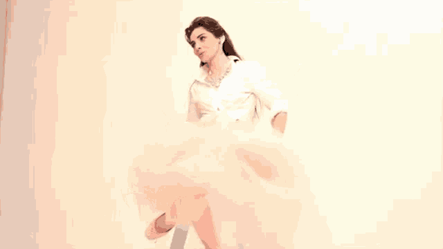 a woman in a white dress is flying through the air while dancing .
