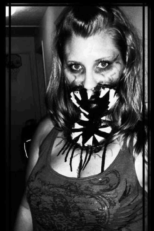 a black and white photo of a woman with her face painted like a spider