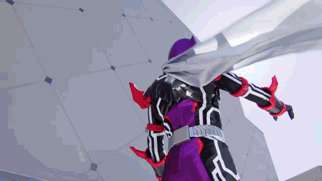 a person in a purple and black superhero costume with a scarf around their neck