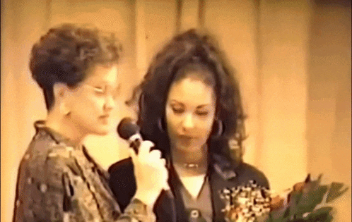 a woman is holding a microphone in front of a woman .
