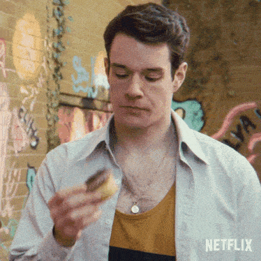 a man eating a donut with a netflix logo on the bottom right