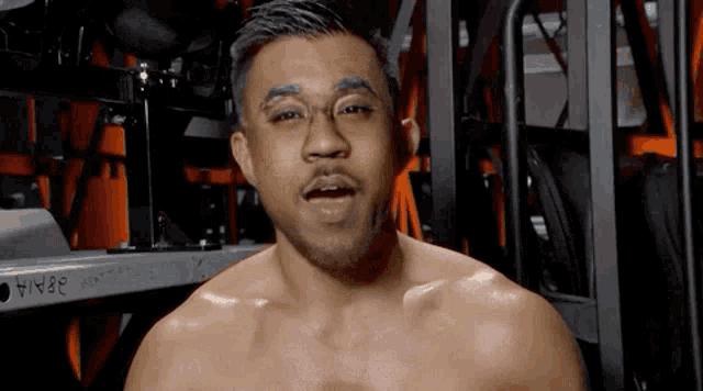 a man without a shirt is standing in front of a shelf that says ' a / a ' on it