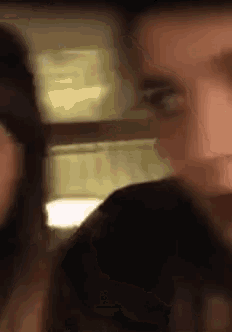 a man and a woman are standing next to each other in a blurry photo .