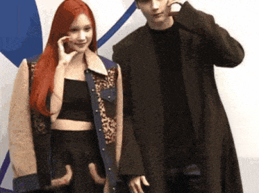 a man and a woman are posing for a picture and the woman has red hair