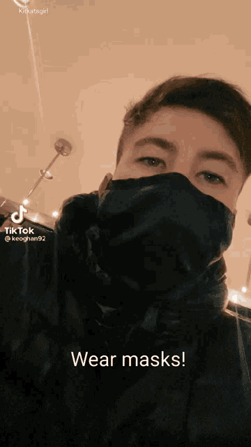 a man wearing a black mask with the words wear masks written below him