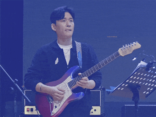 a man playing a guitar with the word victoria on the bottom right
