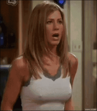 a woman in a white tank top is standing in a room .