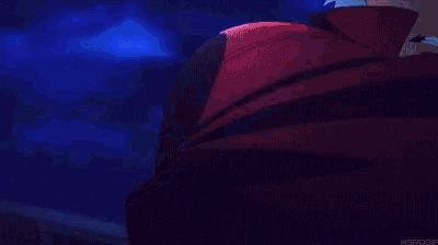 a man is holding a sword in his hand in a dark room .
